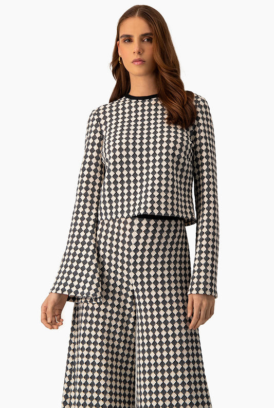 Blusa tejida natural con mangas acampanadas y patrón geométrico.